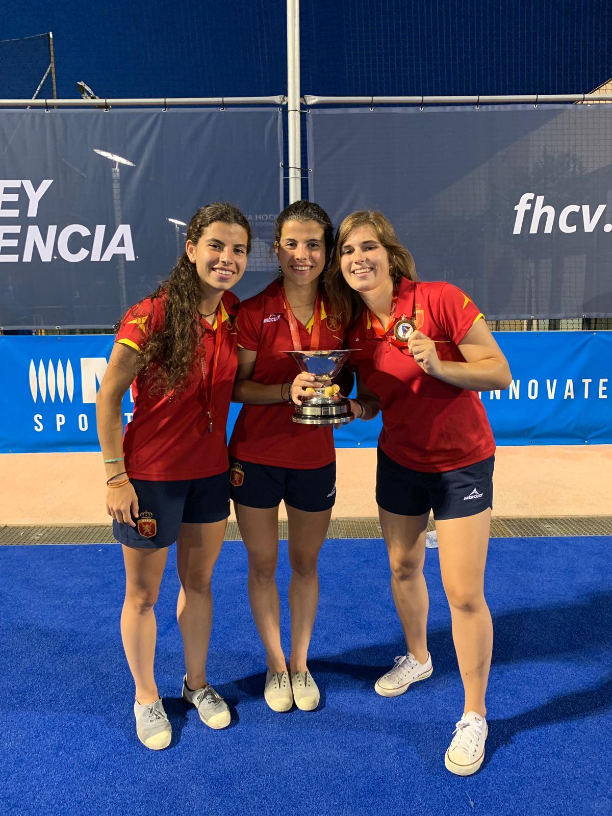 Laura Barrios, Sara Barrios y Ana Pueche (de izda. a dcha.), con sus medallas y el trofeo de campeonas de Europa sub 21.