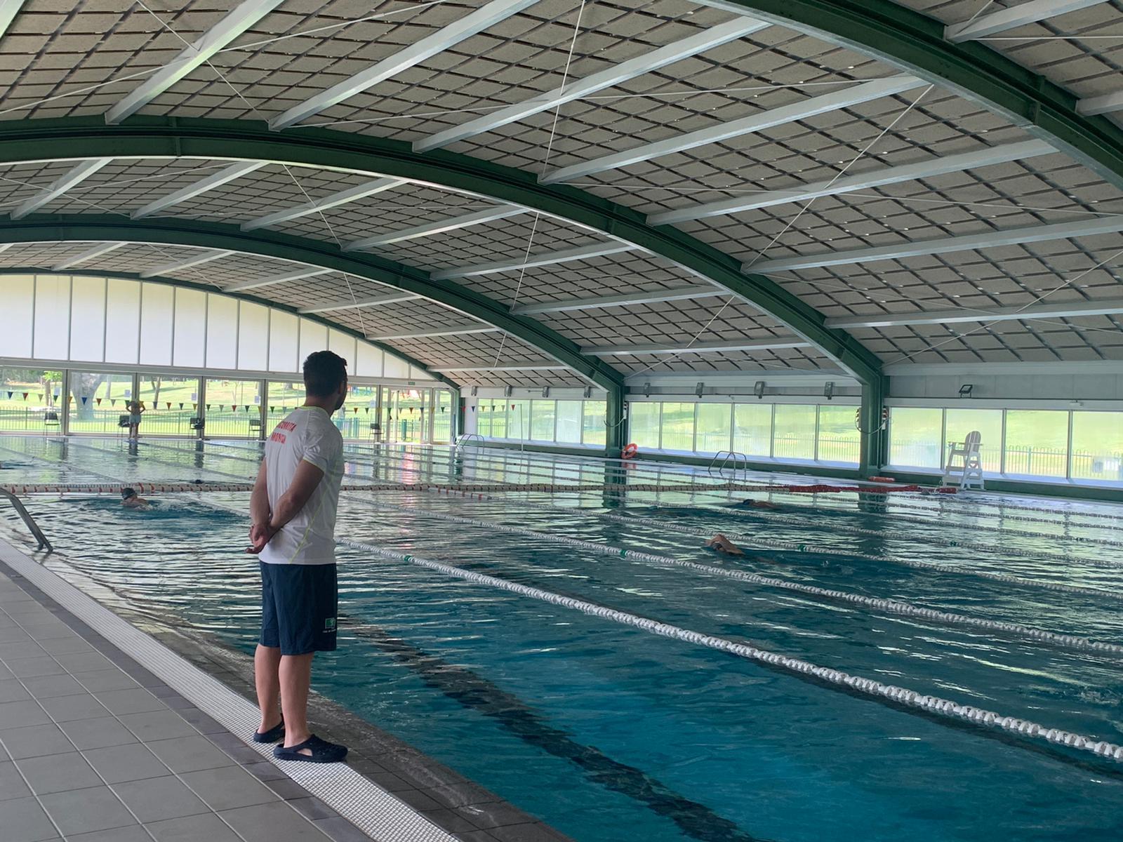 Un socorrista vigila el nado de unos abonados en la piscina cubierta.