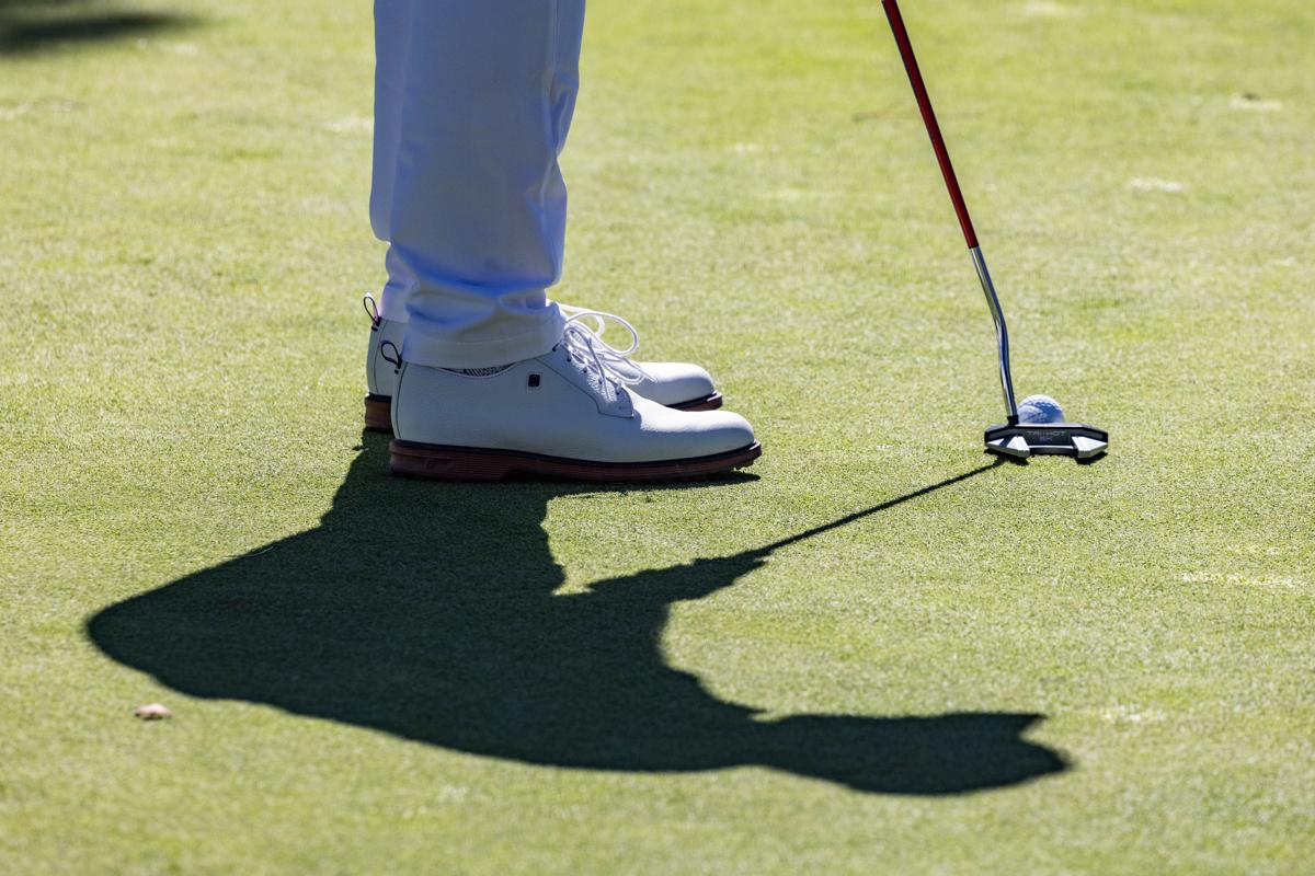 Detalle de un golfista al ejecutar un putt.